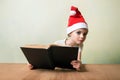 ÃÂ¡ute girl in Santa Claus hat with book